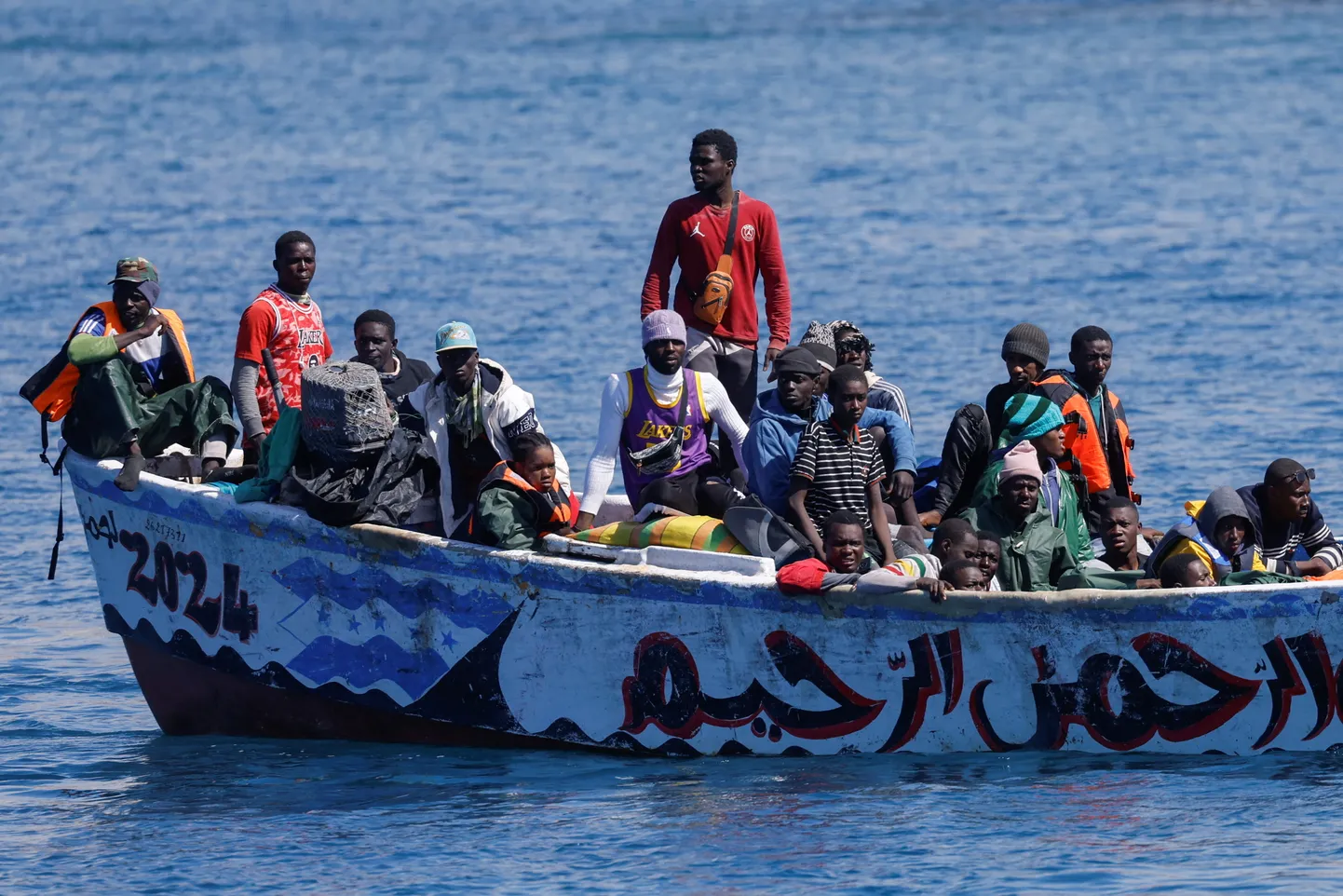 Migranter venter pa at ga i land fra en fiberbad i havnen i Arguineguin Spionen i din lomme: Pegasus og tech-industrien uden samvittighed