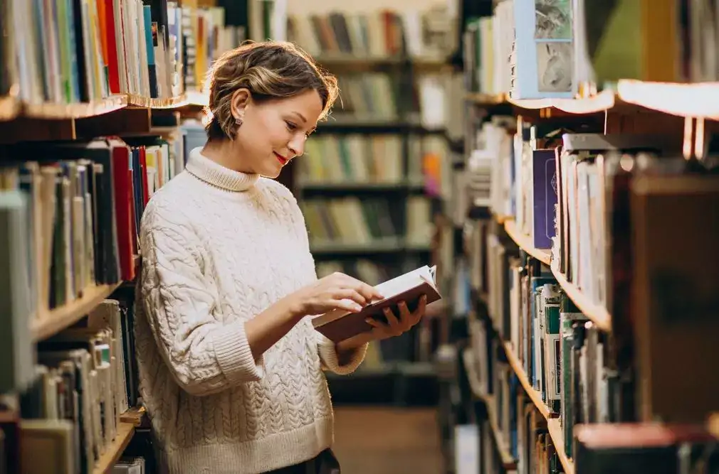Kvinde kikker på en bog i et gammelt bibliotek Automatisk kladde